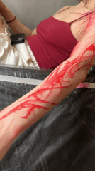 Person receives red abstract tattoo at Moscow studio