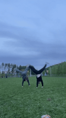 Two women perform cartwheels in Russian field