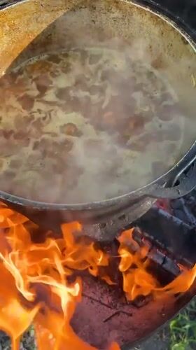 Cast-iron stew simmering over open fire in Kulishi