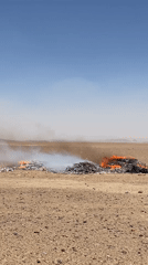 Burning debris piles in arid desert outside Mandisar, Afghanistan