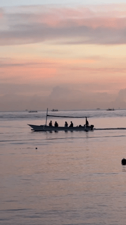 Traditional outrigger boats carry passengers across Buleleng waters at dawn