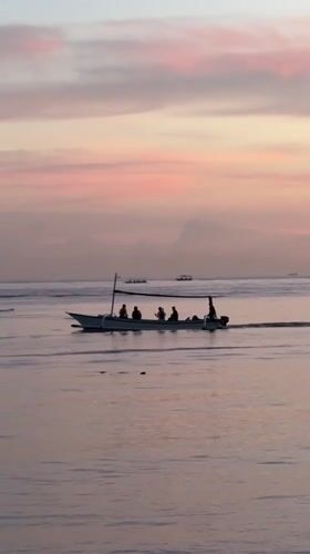 Traditional outrigger boats carry passengers across Buleleng waters at dawn