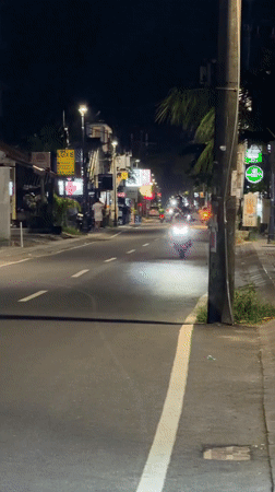 Motorcyclist rides through North Kuta streets at night