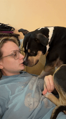 Woman relaxes with dog on couch in Tel Aviv