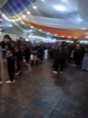 Indoor gathering in Arica under rainbow lights and draped fabric