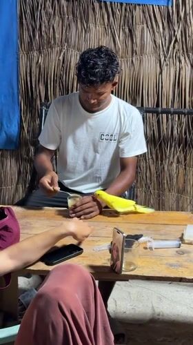 Man feeds parrot peanut butter in Maldives island setting