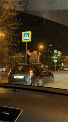 Person Rides Car Roof Through Yekaterinburg Streets