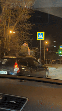 Person Rides Car Roof Through Yekaterinburg Streets