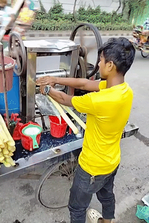 Sugarcane juice cart in action on a Dhaka street