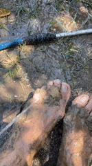 Person rinses muddy feet with hose in Venezuelan village