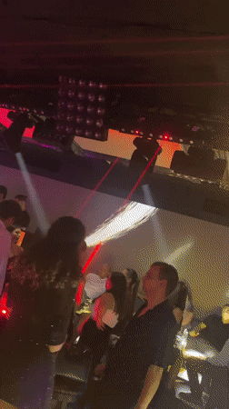 Nightclub scene captured with dancing crowd under red lighting