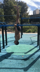 Man performs upside-down exercise on parallel bars in Buenos Aires park