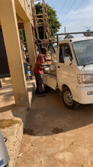 Man loads bags into pickup truck in Bukuru