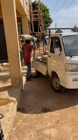 Man loads bags into pickup truck in Bukuru