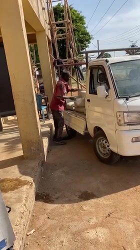 Man loads bags into pickup truck in Bukuru