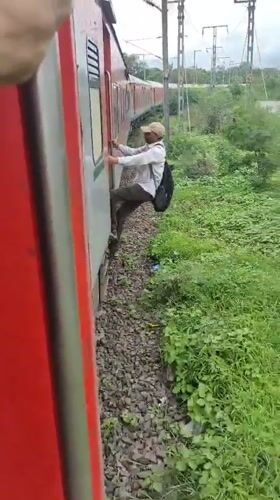 Riding the outside of a moving train through rural India