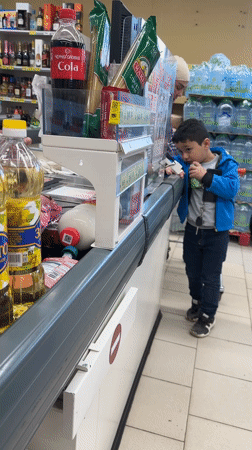 Boy shops at supermarket checkout in Chekhov, Russia
