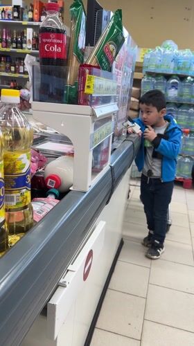 Boy shops at supermarket checkout in Chekhov, Russia