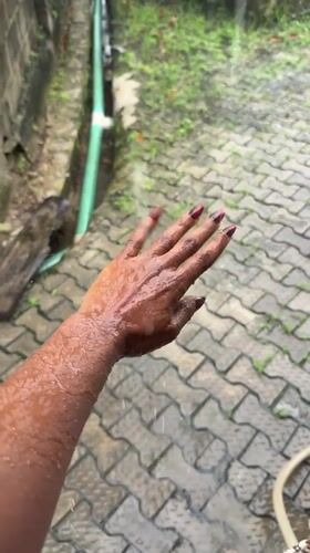 Rain-soaked hand held out in Ado, Nigeria