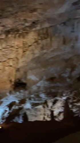 Tourists explore and photograph Lipa Cave formations in Montenegro