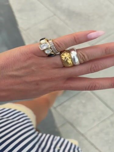 Woman in sunglasses walks Dubai pedestrian walkway wearing jewelry