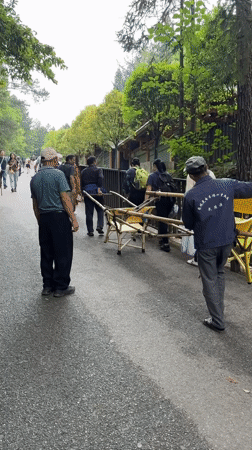Men transport bamboo sedan chair on road in Zhonghu