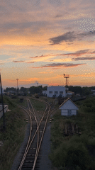 Sunset over a Chaikovsky train yard, tracks and color.
