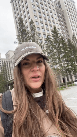 Woman films outdoors in residential Novosibirsk on overcast morning