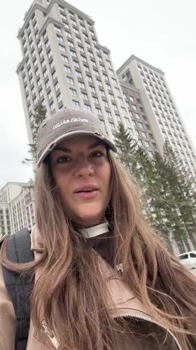Woman films outdoors in residential Novosibirsk on overcast morning