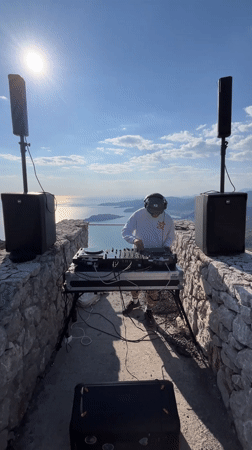 DJ performs on historic stone structure overlooking Montenegro coastline