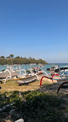 Colorful jukungs line the shore at a Manggis beach terminal