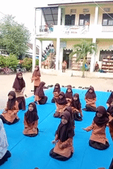 Students in uniform run a coordinated outdoor activity at Indonesian school