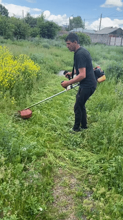 Man operates string trimmer in Gyumri, Armenia