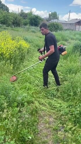 Man operates string trimmer in Gyumri, Armenia