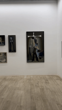 Gallery visitor documents religious artwork and oil paintings in Tbilisi