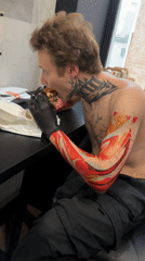 Tattooed man eats burger amid collectibles display in Moscow