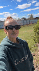 Woman takes selfie in sunny suburban garden setting