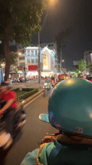 Motorcyclist travels through busy Thủ Đức streets at night