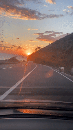 Driver captures sunset over sea from Montenegro highway