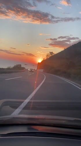Driver captures sunset over sea from Montenegro highway