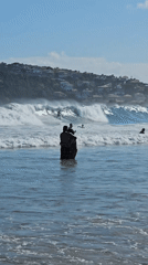 Surfers and swimmers enjoy evening waters in Búzios, Brazil