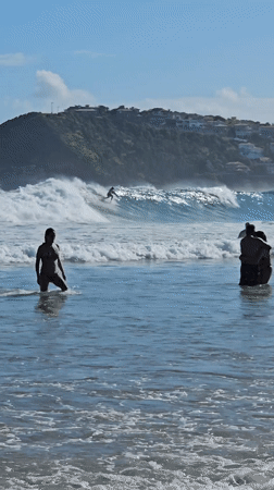 Surfers and swimmers enjoy evening waters in Búzios, Brazil
