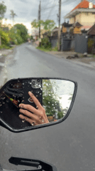 Motorcyclist uses phone during rainy ride in Mengwi