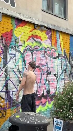 Tattooed figure walking through East London streets, summer afternoon