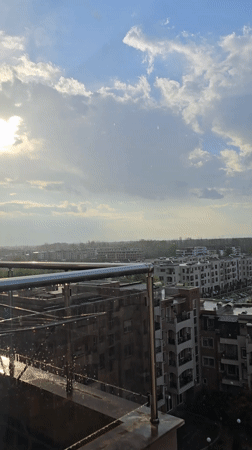 Rainy cityscape captured from elevated balcony view