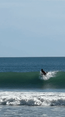 Surfer catches wave at Kuta beach, Indonesia