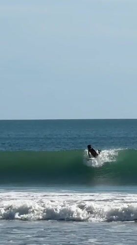 Surfer catches wave at Kuta beach, Indonesia