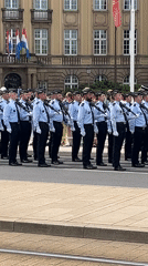Uniformed formation marches past grand official building in Luxembourg City