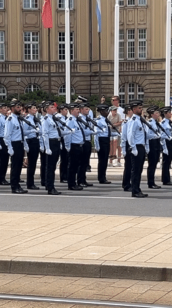 Uniformed formation marches past grand official building in Luxembourg City