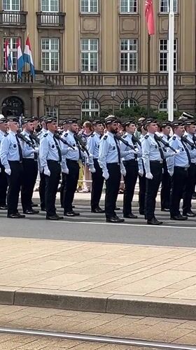 Uniformed formation marches past grand official building in Luxembourg City